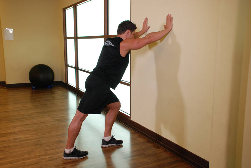 Calf Stretch Hands Against Wall — start position